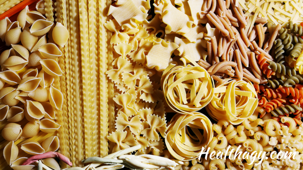 pasta in different shapes and colors, long and thin, spirals, shells, and short and round.  Colors include ivory, gold, red, green, browns.