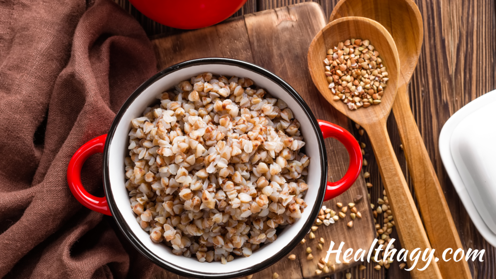 bowl of cooked buckwheat with a spoonful of small raw buckwheat groats or buckwheat seeds