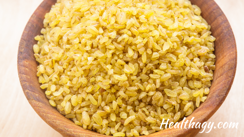 wood bowl filled with bulger wheat, which looks like golden rice grains