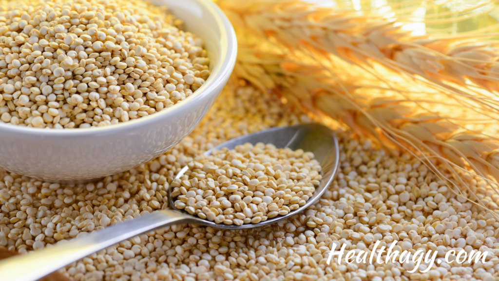 white quinoa seeds with a spoon and a bowl