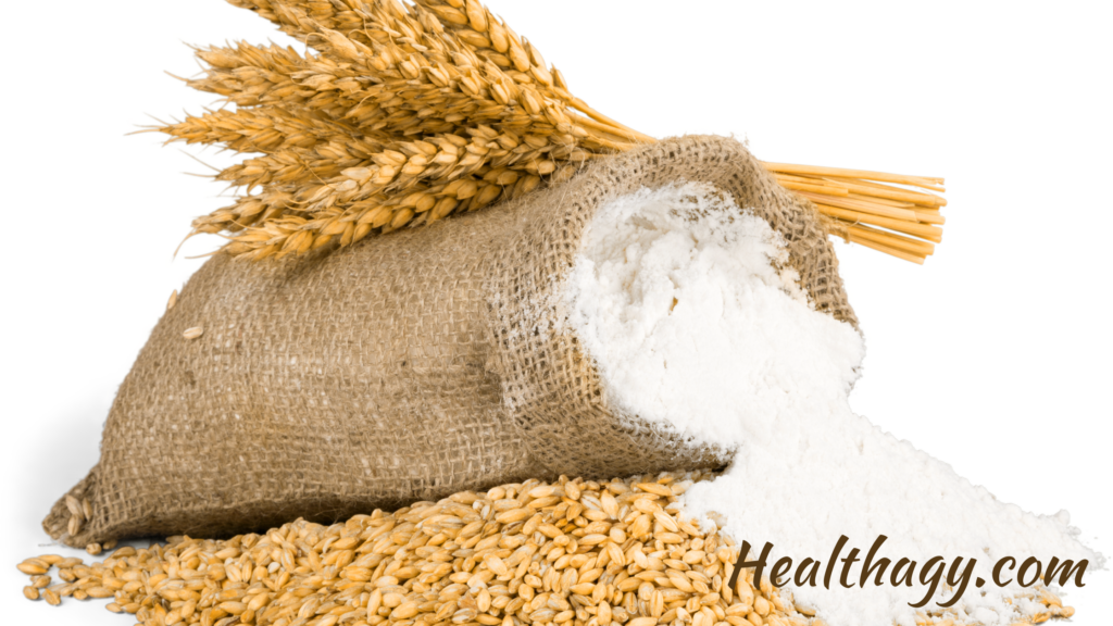 wheat kernels, with wheat flour in a cloth bag with wheat grass on top